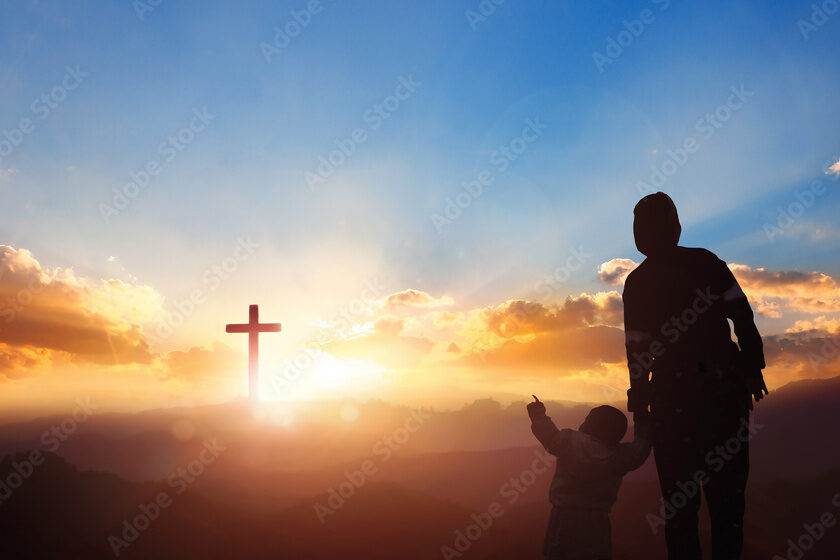 Silhouette mom and son looking for the cross on meadow autumn sunrise background